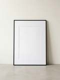 Aluminium Fotolijst Mat Zwart 50x70 - matzwarte aluminium posterlijst 50 x 70 cm van Dekovira, tegen een warmwitte muur in daglicht