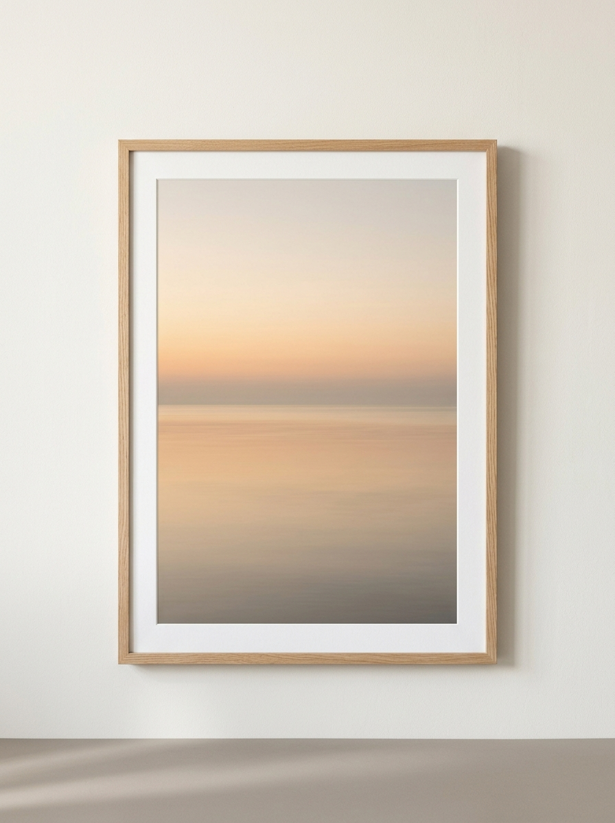 Ingelijste Print Horizon Zonsopgang - grote ingelijste horizonprint in abrikoos en zand van Dekovira, tegen een warmwitte muur in daglicht