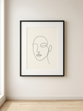 Ingelijste Print Lijnportret Minimal - ingelijste line-art print in matzwarte lijst van Dekovira, tegen een warmwitte muur in daglicht